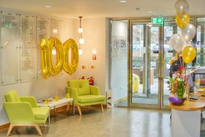 UCEM's reception area with regular balloons on the front desk and centenary balloons on the sitting area shaped as a '100'